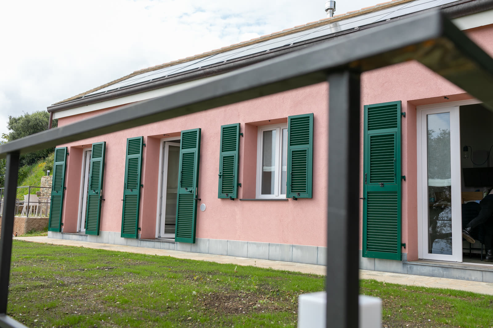 La casa rosa con persiane verdi